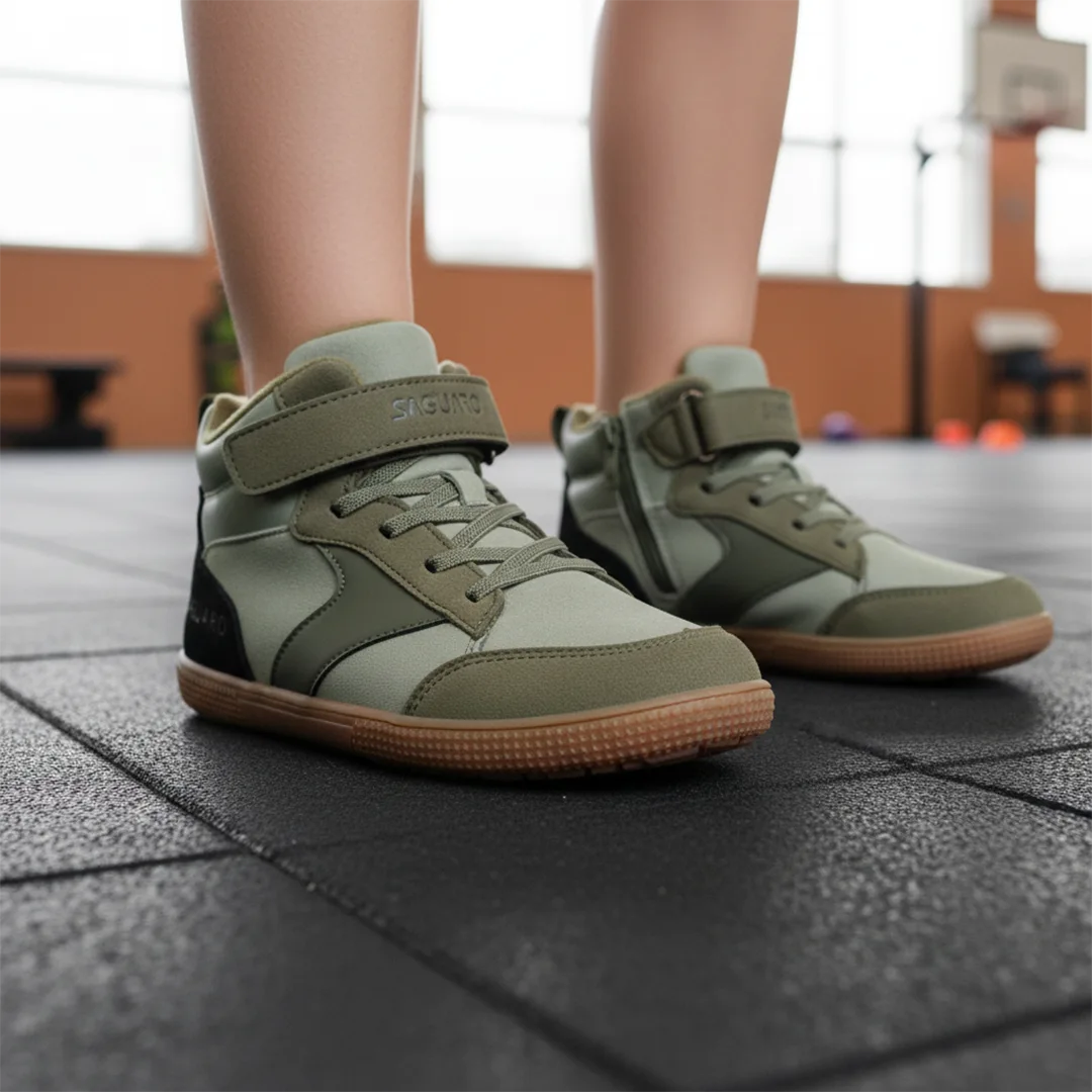Niño en un entorno escolar usando zapatillas anchas infantiles Saguaro color verde olivo.