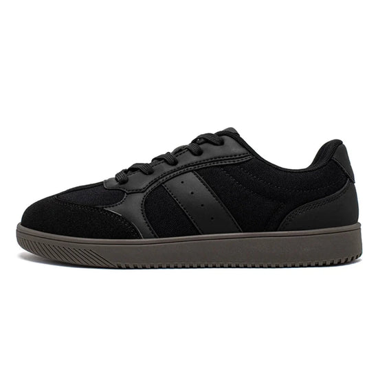Zapatillas anchas negras para hombre con suela plana zero drop y diseño minimalista de transición.