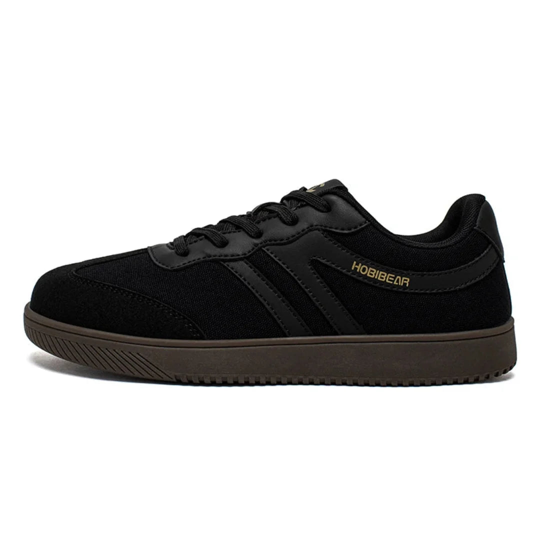 Zapatillas anchas negras para oficina con suela plana zero drop y estilo urbano minimalista.