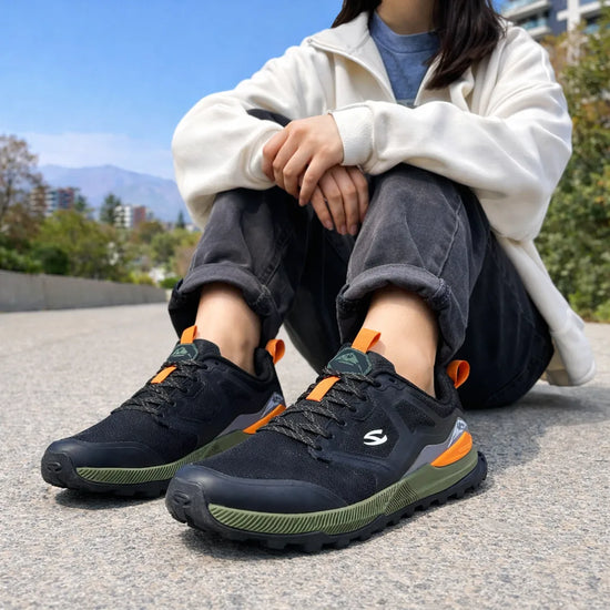 Mujer usando zapatillas anchas de trekking en un entorno urbano, destacando comodidad y estilo deportivo.