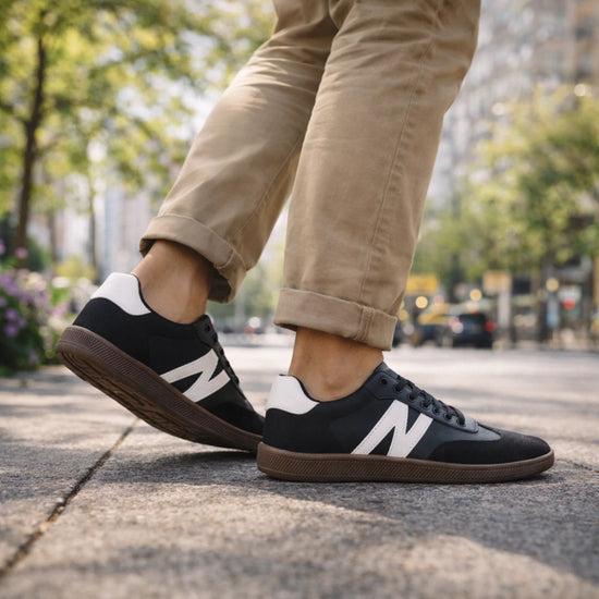 Zancada con zapatillas barefoot hombre negras resaltando la flexibilidad y estilo retro.