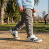Niño caminando en el parque con zapatillas barefoot ZZFaber Kids Niza, mostrando la flexibilidad de la suela en pasto.