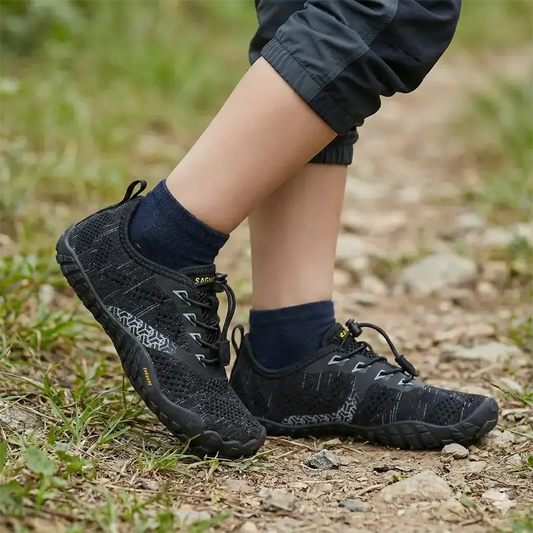 Niño utilizando Zapatillas barefoot Saguaro Kids Smart I negras en terreno