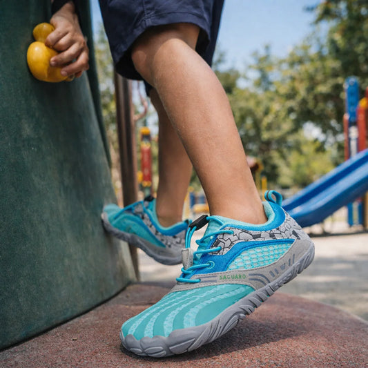 Niño usando zapatillas niña en juegos de plaza, calzado respetuoso ideal para escalar y correr.