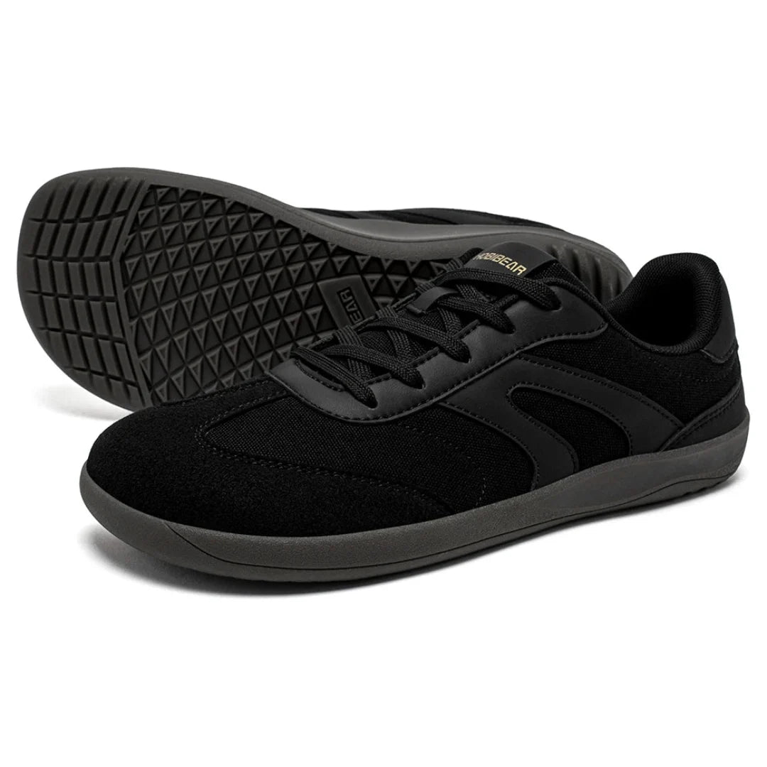 Par de zapato minimalista negro con suela de caucho flexible ideal para iniciar la transición al barefoot.
