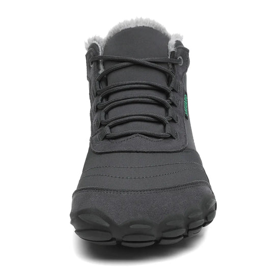 Vista frontal de bota gris resaltando la puntera ancha y sistema de ajuste.