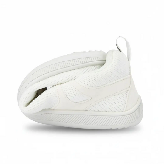 Zapatilla ZZfaber Comfy I blanca doblada mostrando flexibilidad.