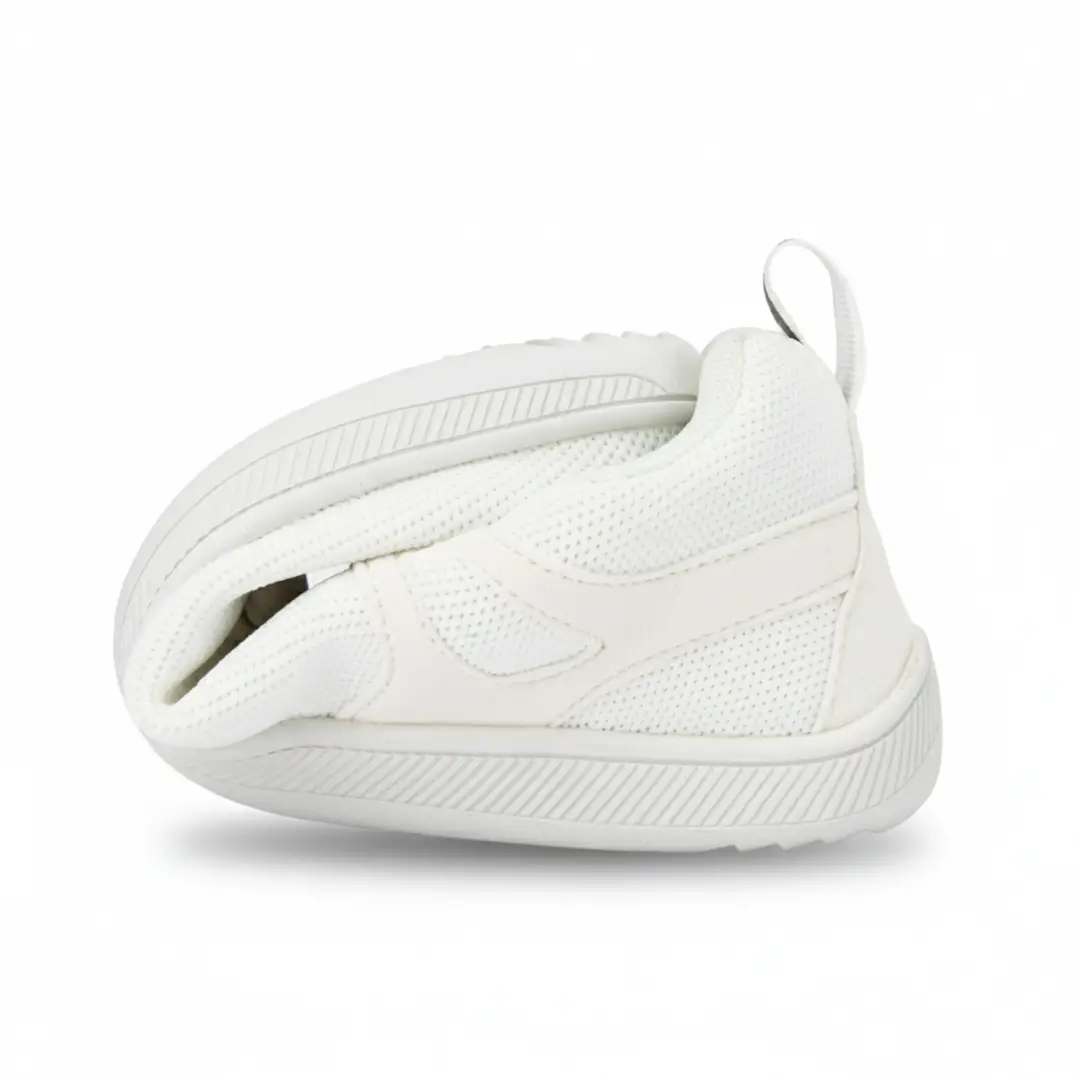 Zapatilla ZZfaber Comfy I blanca doblada mostrando flexibilidad.