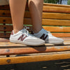 Persona usando zapatillas ZZfaber Niza I blanco con vinotinto en exterior.